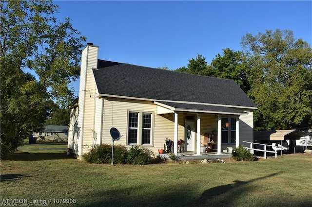 view of front of house with a chimney, a porch, roof with shingles, and a front lawn