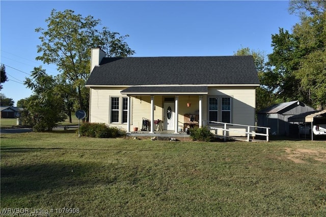view of front of house featuring covered porch, a chimney, roof with shingles, and a front yard