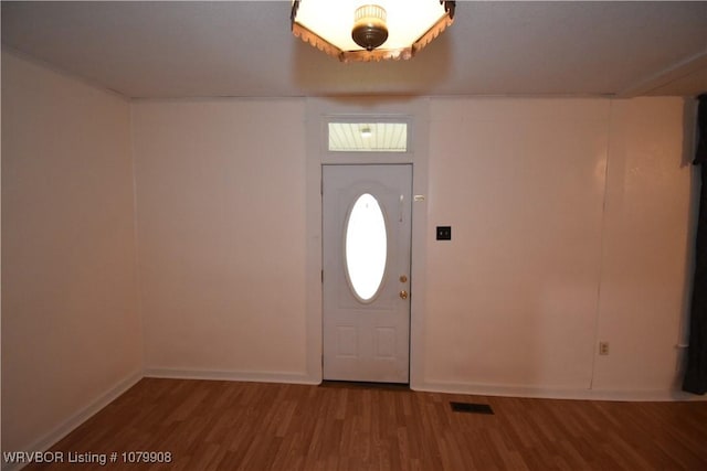 foyer entrance with visible vents, baseboards, and wood finished floors