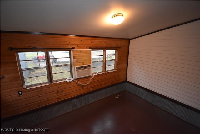 spare room with cooling unit, wood walls, and a healthy amount of sunlight