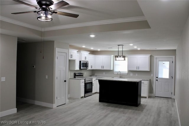 kitchen featuring a center island, light hardwood / wood-style flooring, appliances with stainless steel finishes, pendant lighting, and white cabinets