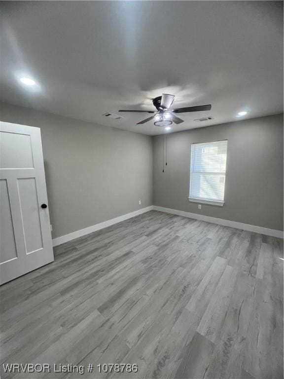 unfurnished room featuring wood finished floors, baseboards, and ceiling fan