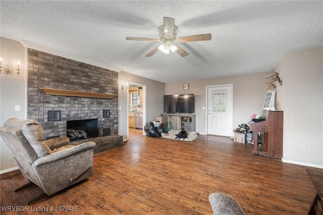 living room featuring a fireplace, a ceiling fan, a textured ceiling, wood finished floors, and baseboards