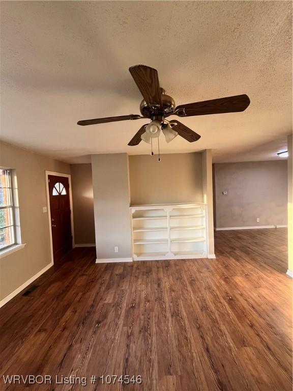 interior space with a textured ceiling, ceiling fan, and dark hardwood / wood-style floors