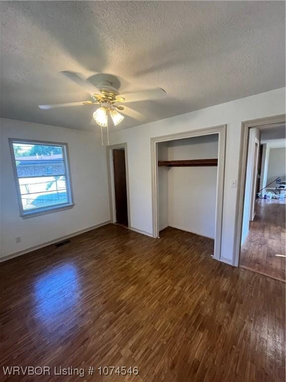 unfurnished bedroom featuring a textured ceiling, a closet, dark hardwood / wood-style floors, and ceiling fan