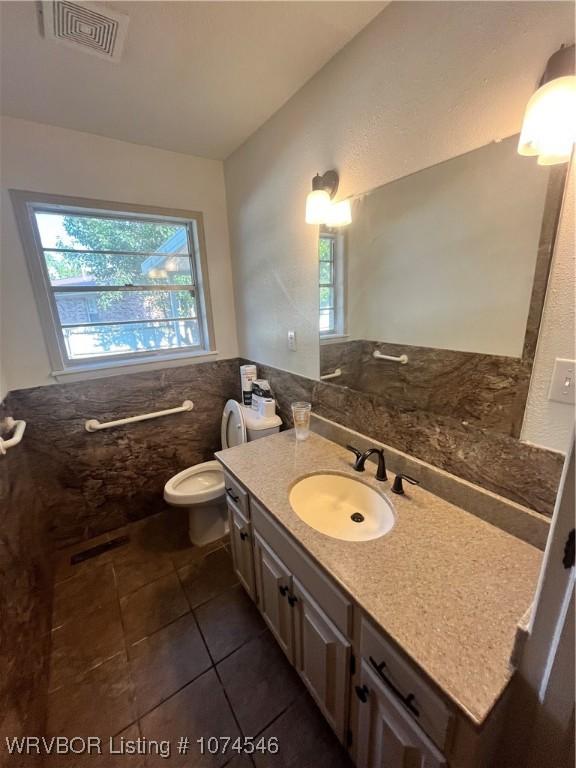 bathroom with tile patterned flooring, vanity, and toilet