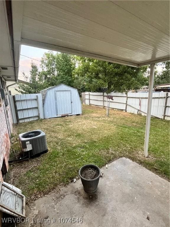 view of yard featuring cooling unit, a patio area, and a storage shed