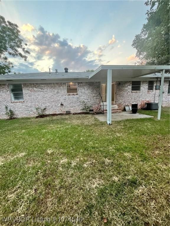 rear view of house featuring a patio area, a yard, and central air condition unit