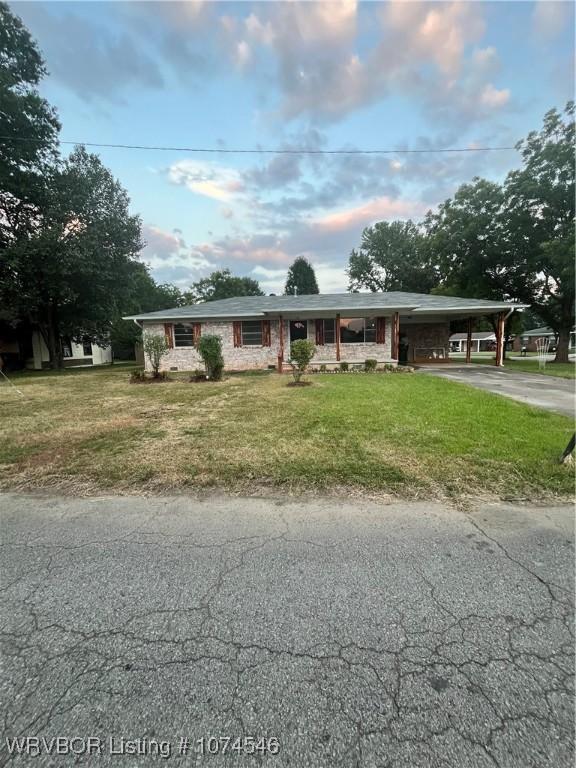 view of front of property with a front lawn and a carport