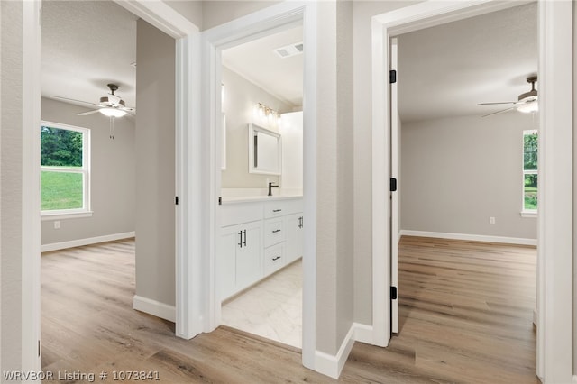 corridor with sink and light hardwood / wood-style floors