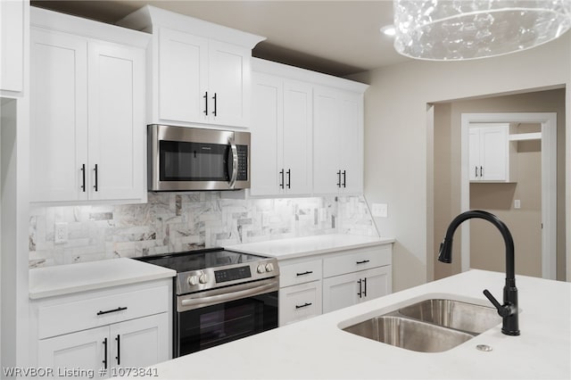 kitchen with backsplash, white cabinetry, sink, and stainless steel appliances