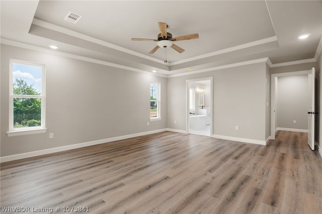 empty room featuring a tray ceiling, ceiling fan, and crown molding