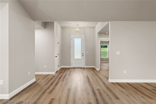 foyer with a chandelier and light wood-type flooring