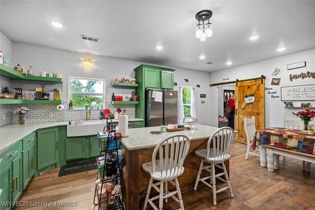 471962 E 720, Westville, OK 74965 - kitchen with freestanding refrigerator, green cabinetry, open shelves, a sink, and a barn door