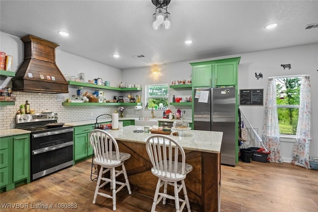 471962 E 720, Westville, OK 74965 - kitchen featuring stainless steel appliances, green cabinetry, custom exhaust hood, open shelves, and light wood-style flooring