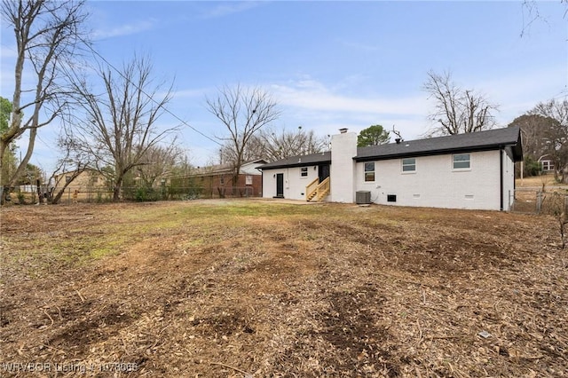 rear view of property featuring a yard and central air condition unit