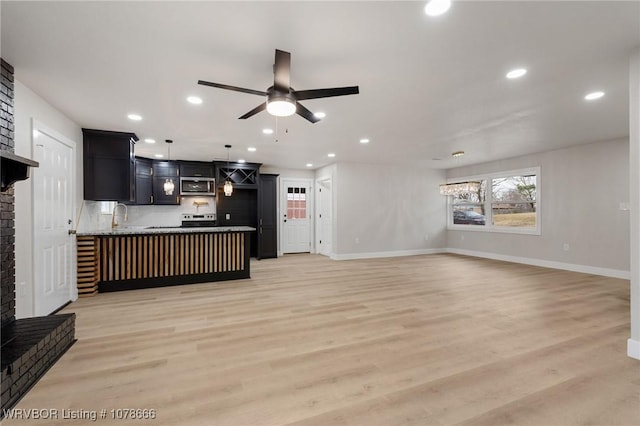 living room featuring ceiling fan, sink, and light hardwood / wood-style floors