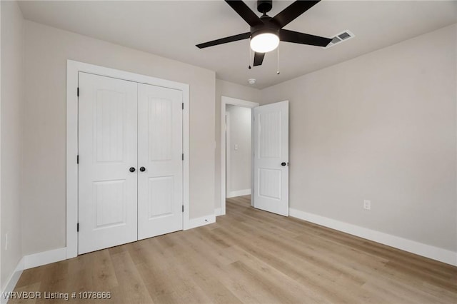 unfurnished bedroom featuring ceiling fan, light hardwood / wood-style floors, and a closet