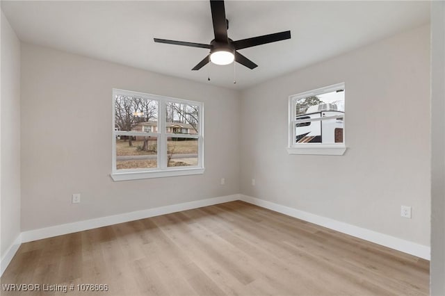 empty room with ceiling fan, light wood-type flooring, and a wealth of natural light