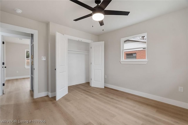 unfurnished bedroom featuring multiple windows, light hardwood / wood-style floors, and a closet