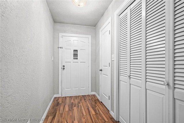 doorway featuring dark hardwood / wood-style flooring and a textured ceiling