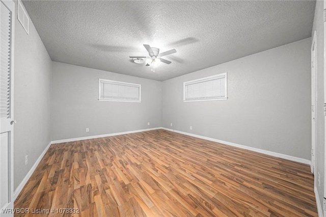 empty room with hardwood / wood-style floors, a textured ceiling, and ceiling fan