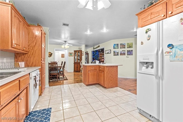 kitchen featuring kitchen peninsula, light tile patterned floors, white appliances, and ceiling fan