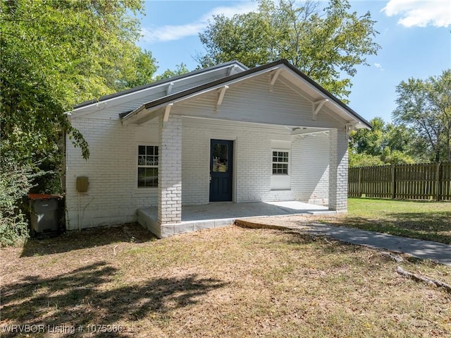 rear view of property with a lawn and a patio