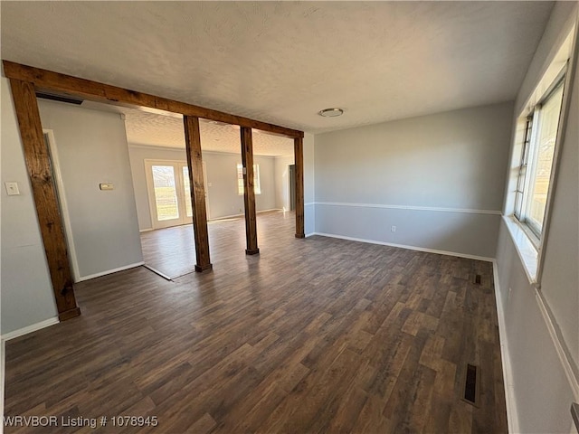 19 Lincoln Dr, Charleston, AR 72933 - spare room with visible vents, a textured ceiling, dark wood-type flooring, and baseboards