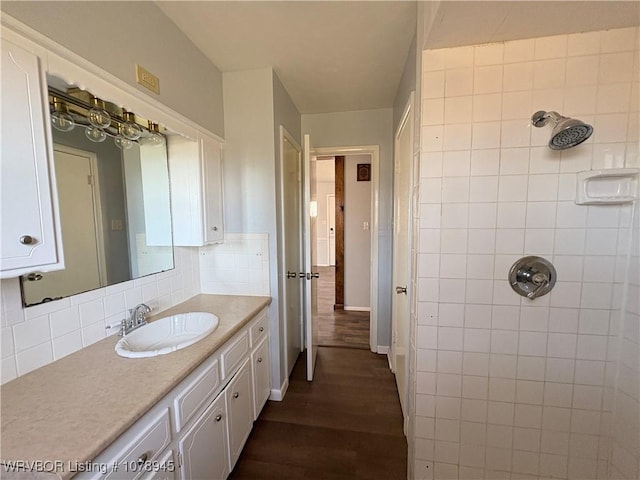 19 Lincoln Dr, Charleston, AR 72933 - bathroom featuring baseboards, a tile shower, decorative backsplash, wood finished floors, and vanity