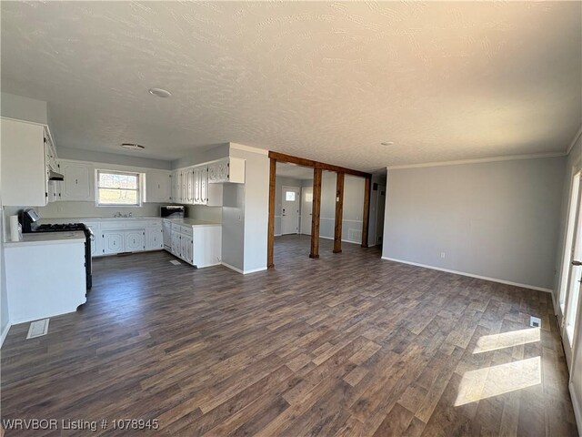 19 Lincoln Dr, Charleston, AR 72933 - kitchen featuring white cabinetry, stainless steel appliances, light countertops, baseboards, and dark wood-style flooring