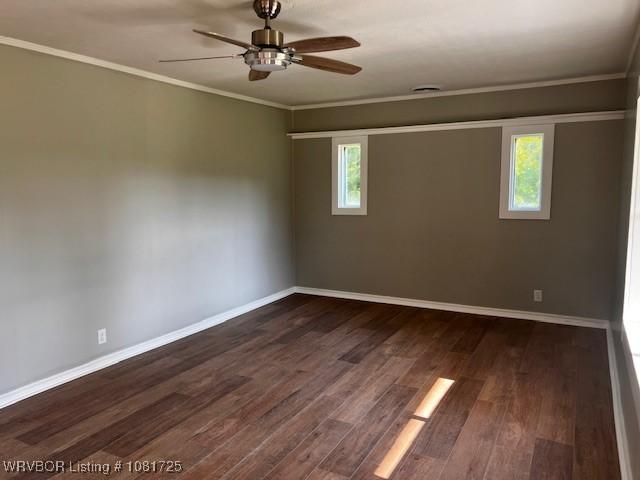310 Butler St, Lavaca, AR 72941 - empty room featuring dark wood-style floors, healthy amount of natural light, a ceiling fan, and crown molding