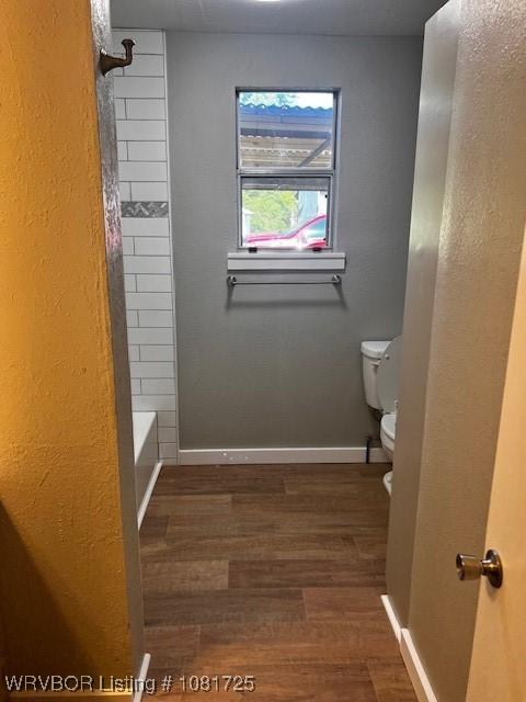310 Butler St, Lavaca, AR 72941 - bathroom featuring wood finished floors and tub / shower combination