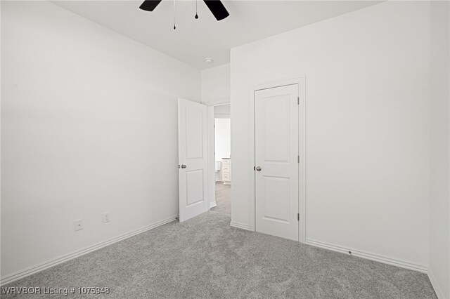 carpeted empty room featuring ceiling fan