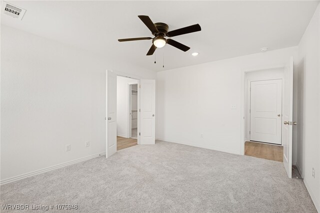 unfurnished bedroom featuring light carpet and ceiling fan