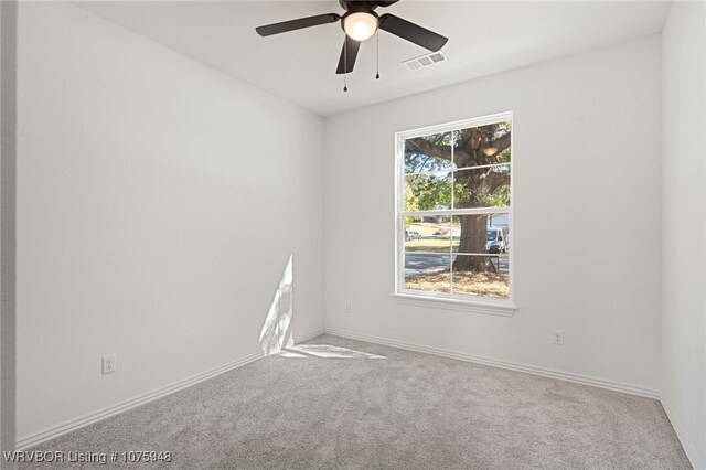 carpeted spare room featuring ceiling fan