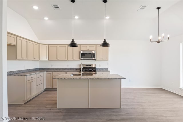 kitchen with appliances with stainless steel finishes, an island with sink, pendant lighting, and sink