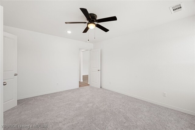 unfurnished room with ceiling fan and light carpet