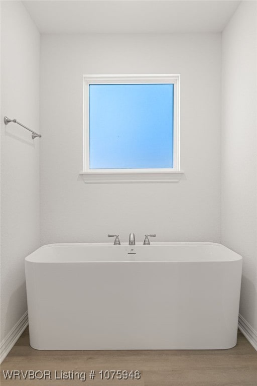 bathroom featuring a tub to relax in and hardwood / wood-style floors