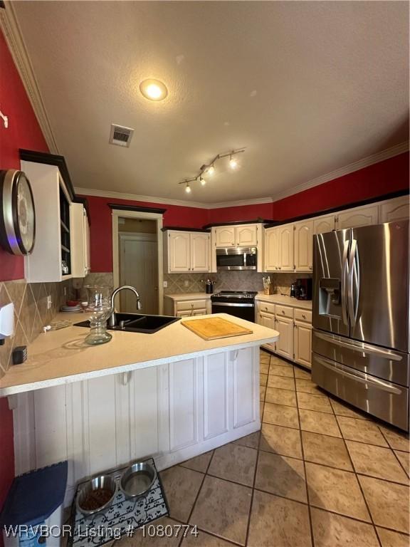 108722 4768th Rd, Roland, OK 74954 - kitchen with ornamental molding, visible vents, a sink, a peninsula, and appliances with stainless steel finishes