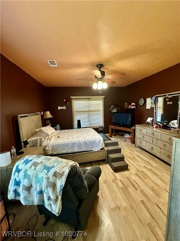 108722 4768th Rd, Roland, OK 74954 - bedroom featuring a ceiling fan, light wood-style floors, visible vents, and vaulted ceiling