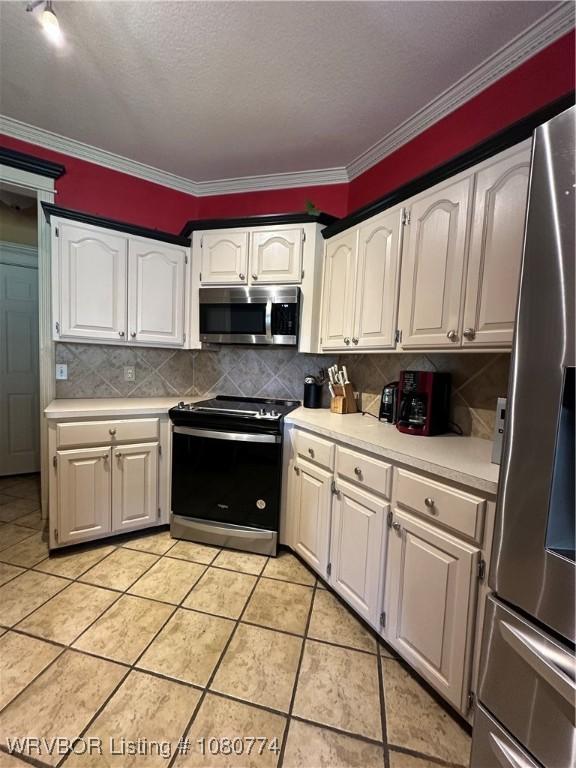 108722 4768th Rd, Roland, OK 74954 - kitchen with crown molding, white cabinetry, backsplash, light countertops, and appliances with stainless steel finishes