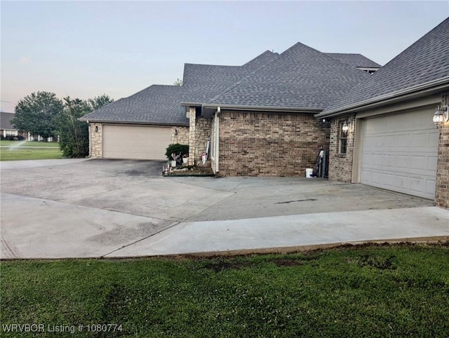 108722 4768th Rd, Roland, OK 74954 - view of side of home featuring concrete driveway, roof with shingles, a garage, and brick siding