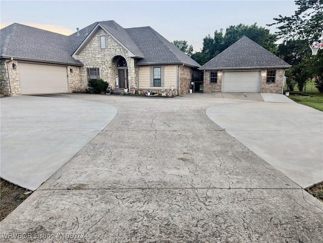 108722 4768th Rd, Roland, OK 74954 - french country style house with concrete driveway, stone siding, and a shingled roof