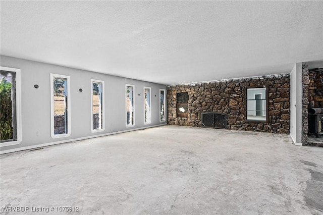 unfurnished living room featuring a textured ceiling and a fireplace