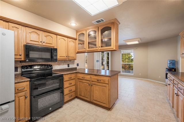 kitchen featuring kitchen peninsula, tasteful backsplash, dark stone counters, black appliances, and light tile patterned floors