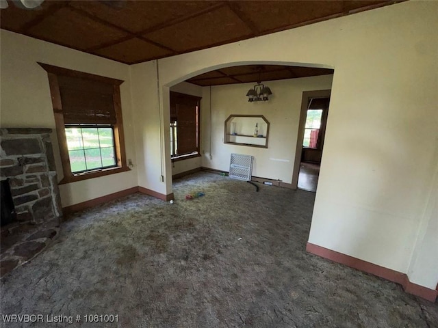 464085 E 1020th Rd, Sallisaw, OK 74955 - unfurnished living room with baseboards, plenty of natural light, arched walkways, and carpet flooring