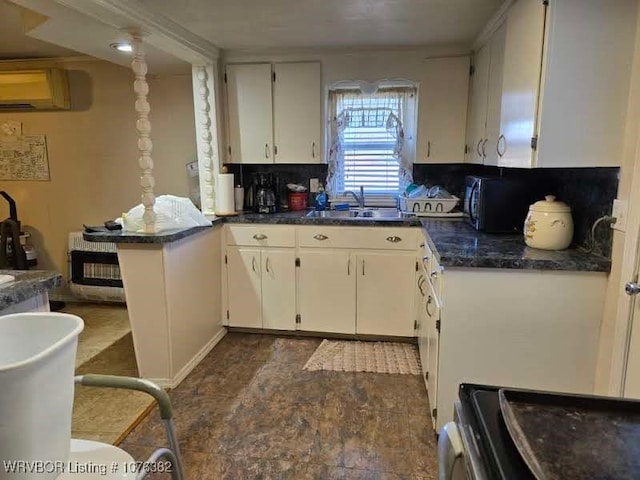 kitchen featuring white cabinets, backsplash, sink, and a wall unit AC