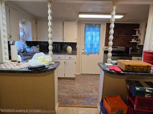 kitchen featuring tasteful backsplash, sink, light tile patterned floors, white cabinets, and stainless steel electric range oven