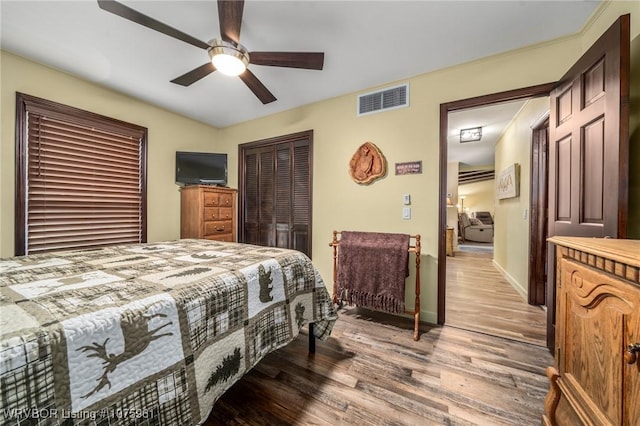 bedroom featuring hardwood / wood-style flooring, ceiling fan, and a closet